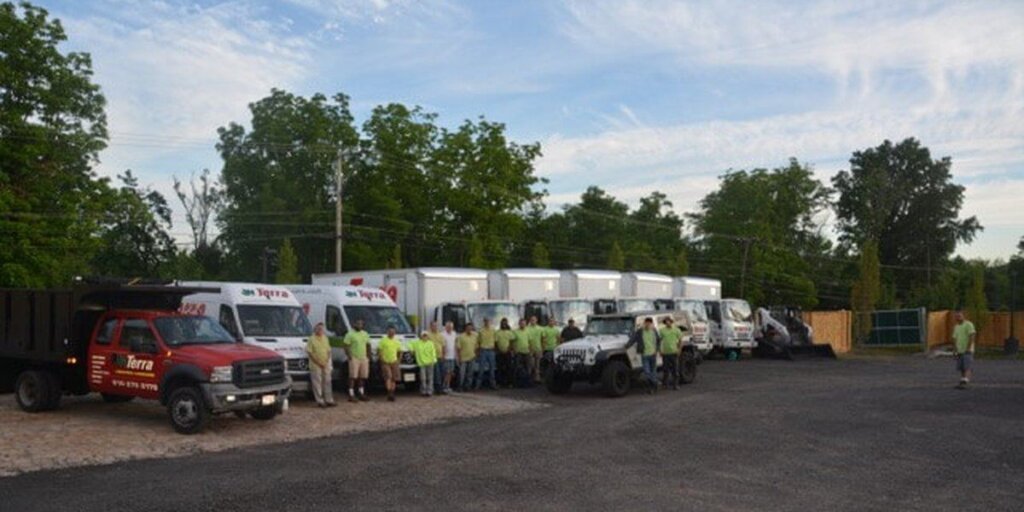 The Terra crew lined up in front of their trucks, trailers, and a Jeep before heading out on a job.